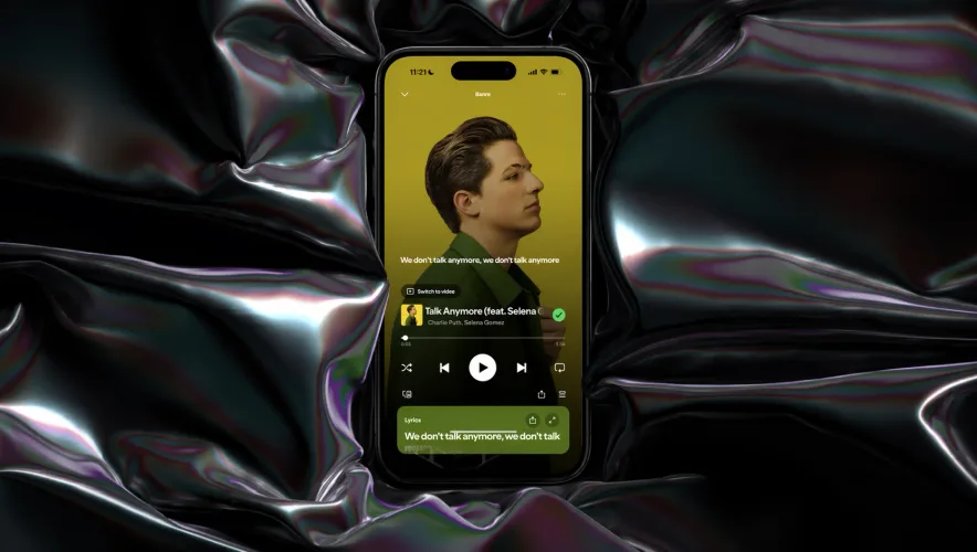 Press Play now-playing screen on a phone, over liquid chrome